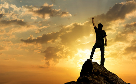 Man on the peak of mountain and sunlight , success,winner, leader growth vision leadership spring time healthy imagination sky sport outdoor business friendship relationship conceptの写真素材