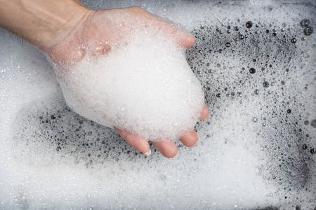 Hand of man with bubble from washingの写真素材