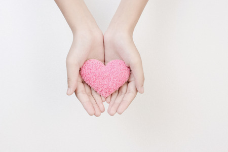 Female hands holding pink heart silk on white background top view , art abstract holiday valentine dayの写真素材