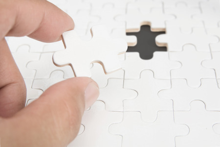 Man hand holding single white jigsaw puzzle , conceptの写真素材