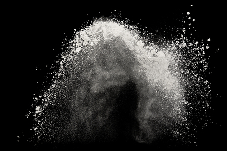 White powder or flour explosion isolated on black background  freeze stop motion object designの写真素材