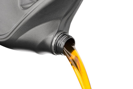 Pouring oil lubricant motor car from gray bottle on isolated white backgroundの写真素材