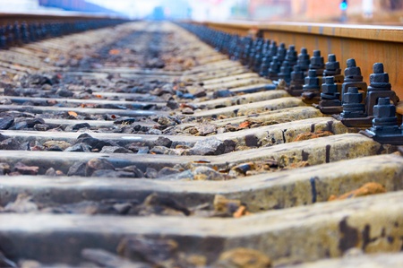Perspective railway tracks. A rusty rail attached by black bolts to cross-tiesの写真素材