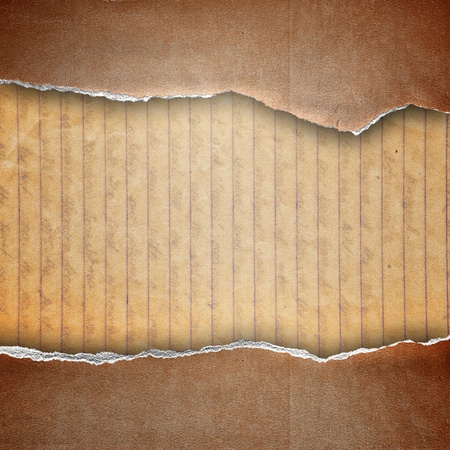 riped brown cardboard cover on guideline paper backgroundの写真素材