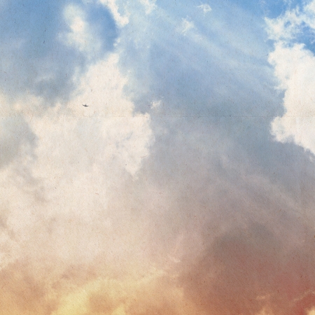 clouds on a textured vintage paper background, with grunge stainsの写真素材