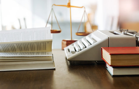 Place of work on wooden desk have book and old typewriter with scales.  Business lawyer concept