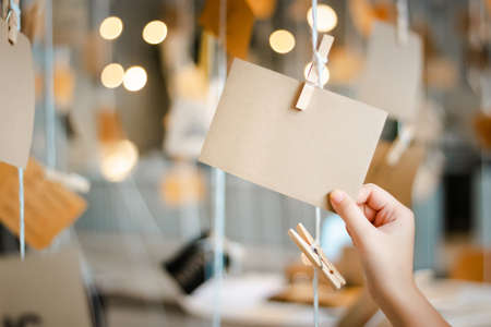 Closeup girl hand golding empty notepad tied to the yarn for people to write greetingsの写真素材