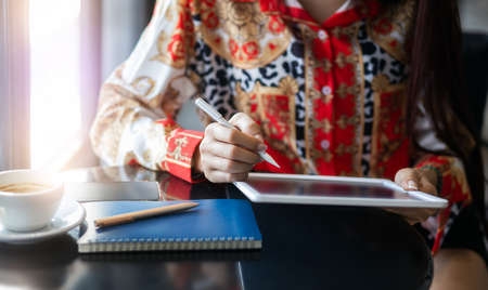 Close up young female using mobile app in digital tablet working onlineの写真素材