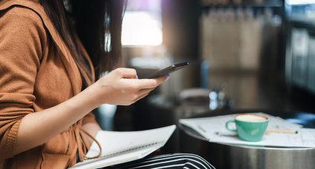 Close up. young asian woman holding smartphone and using mobile app to work online
