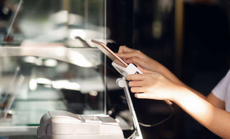 Close-up of hand young asian woman use digital tablet to receive orders from customersの写真素材