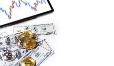 Focus on golden coin with silver coin and dollar, Digital tablet with graph on screen on white background. Concept invest in cryptocurrencyの写真素材