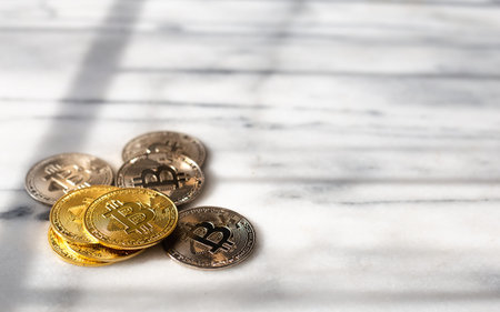 Focus on golden and silver coin on marble desk with black and white texture Concept invest in...