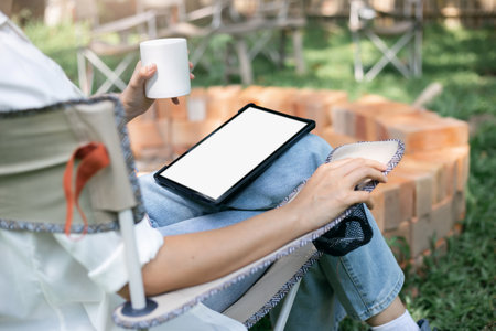 Young asian woman in casual clothes using digital tablet working online outdoor, female investor use tablet computer to trading stock and shopping or paying onlineの写真素材