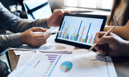 Business concept. Business people discussing the charts and graphs in tablet computer about...
