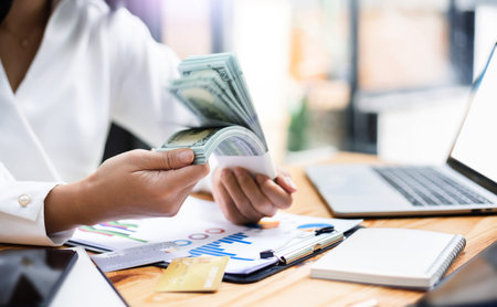 Motion blur of bank note in female hand, Young asian businesswoman shaking bank note in her hand,...
