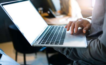 Close up view, focus on hand businessman holding and use computer laptop working and meeting online with his business groupの写真素材