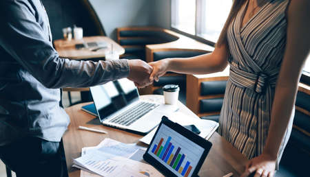 businesswoman handshaking with businessman at meeting. Collaborative teamwork. making deal and satisfied with good resultの写真素材