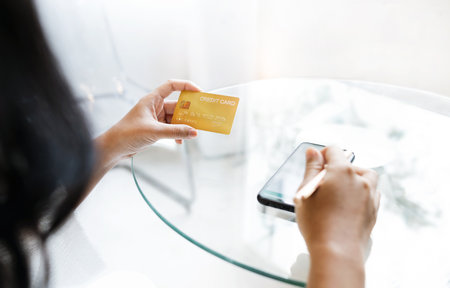 Close up view, young asian woman holding credit card and use smart phone to shopping online and paying order, People relax on holiday use technology from smart phone for the convenience of daily useの写真素材