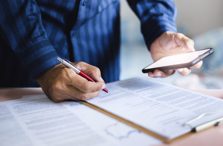 Asian businessman using mobile phone to Verify business information from partners and check the contract before signingの写真素材