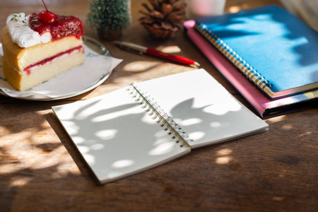 Sofe focus at blank note book with christmas cake, note book put on tablet computer, blurred small...