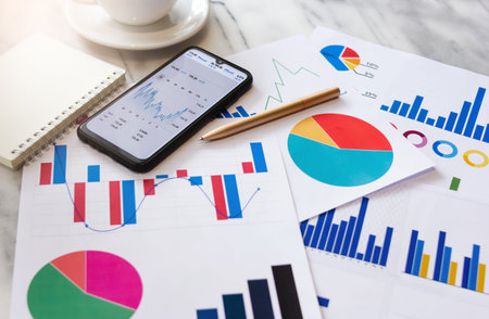 Business people using mobile phone to analysis of investment plans in stocks with paperwork and...