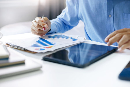 Asian businessman analysis investment chart and use tablet computer searching data of investment to start new business and investment project in the futureの写真素材