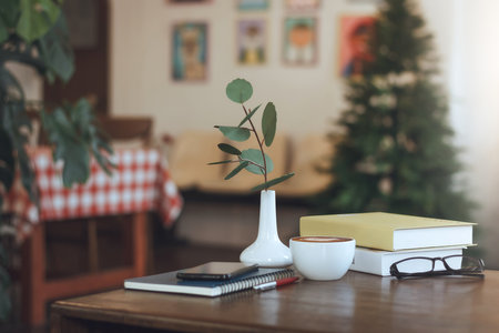 Latte coffee in white cup with mobile phone put on diary book, people taking a break during a day with reading book in cafeの写真素材