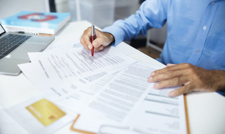 Accountant working on desk with laptop checking business document and loan, bank statement and...