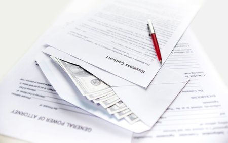 Close-up view, business contract and work document with dollar in white envelope and pen on desk....