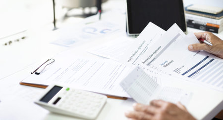 A man work at home use tablet and learning various documents about business, checking bank statement...