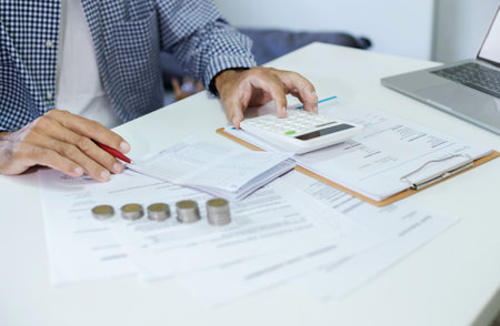 Asian man calculate income from starting a new business SME online. check order and passbook that the customers payingの写真素材