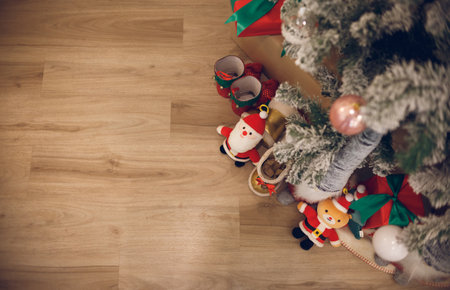 Top view, decorate christmas tree with santa claus doll, gift boxs and toy on wooden floorの写真素材