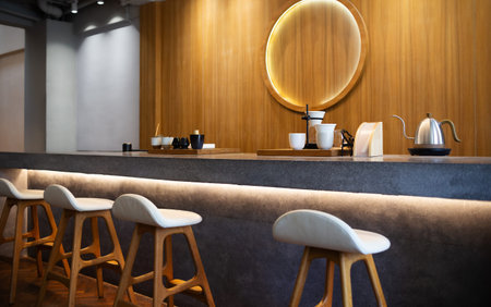 Seat and wooden counter with coffee equipment on counter bar with wooden wall on backgroundの写真素材