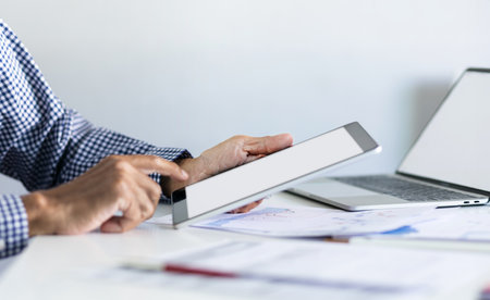 Businessman in office using tablet with documents and chart for analyzing data of investment to make investment plan for a future, financial investment concept.の写真素材