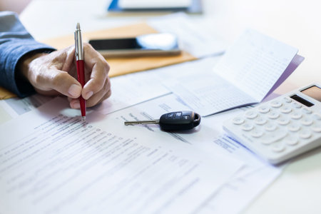 Men's hand holding pen checking personal loan contract with passbook and bank statement to apply for...
