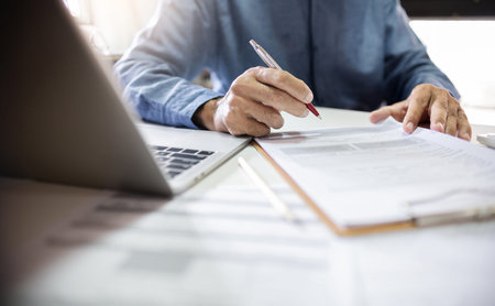 Asian businessman working with laptop and review document report at office. legal expert,...