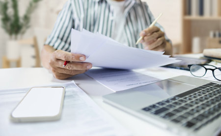 Asian man entrepreneur working at home checking about business document, report and business...