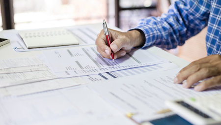 Asian man checking bank statement, financial report, expenses from financial bills, calculate incom...