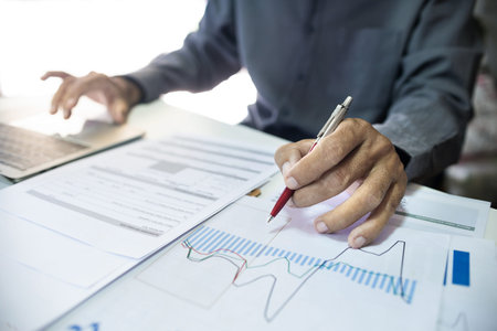 Asian businessman analyzing investment charts with laptop computer, investment planning and business...