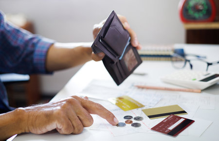 stressed asian man hand open empty wallet not have money to pay, not able payment bill or expense with bank after spend via credit card, debt financial conceptの写真素材