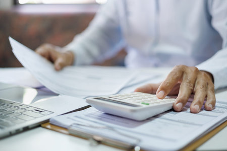 close-up shot, accountants working in office use calculators to calculate business costs, profits...