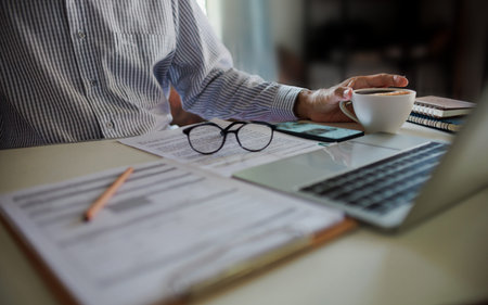 asian businessman have coffee drink while working and meeting online with business group via laptop...