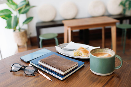 coffee drink and note book, diary for taking note with breakfast on wooden tableの写真素材