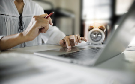 housewife in casual clothes working online via laptop at home, asian middle-aged woman start new business onlineの写真素材