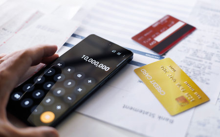 man hand using calculator via mobile app to calculate credit card debt checking receipt and...