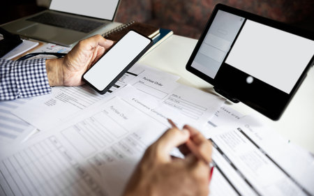 asian man working online via mobile phone, tablet and laptop checking e-commerce form and order from customers, e-commerce online business conceptの写真素材