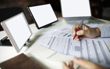 close up shot, hand of businessman working and meeting online with  digital tablet and laptop checking business contract, various documents working at home and start e-commerce businessの写真素材