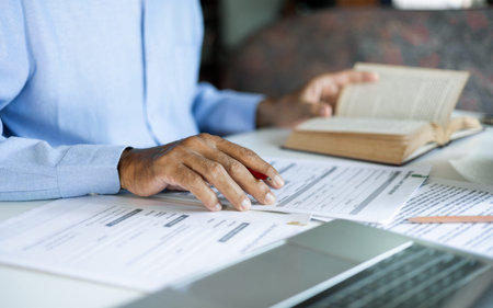 asian man checking business document find knowledge in book using laptop to working online via...