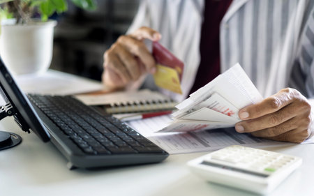 close up shot, asian man holding many receipt and financial bills from spending via credit card and calculate expenses before paying debtの写真素材