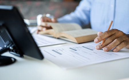 asian man checking business document find knowledge in book using tablet to working online via...